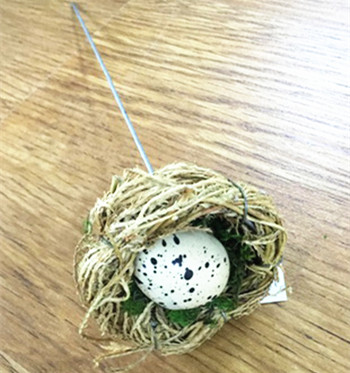Grass easter bird nest with stick and egg
